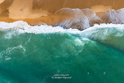 jeu de vagues sur une plage de sable sur la côte landaise avec un surfeur depuis le ciel